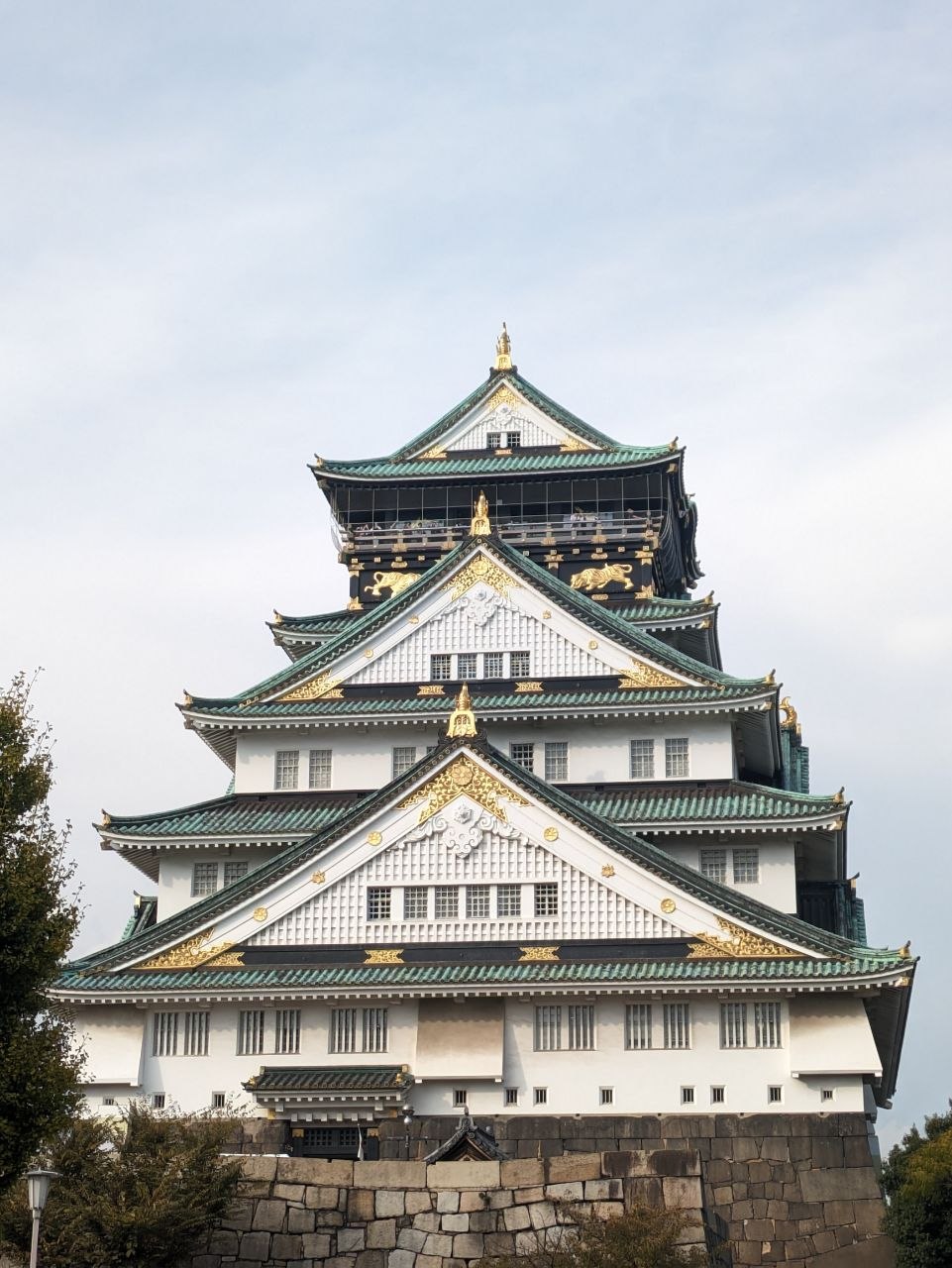 Osaka Castle main tower facade with green tiled roofs and gold decorations