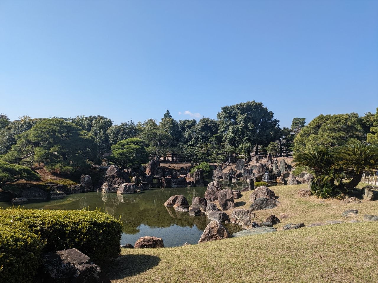 Rock and pond garden with lush trees at Nijo Castle