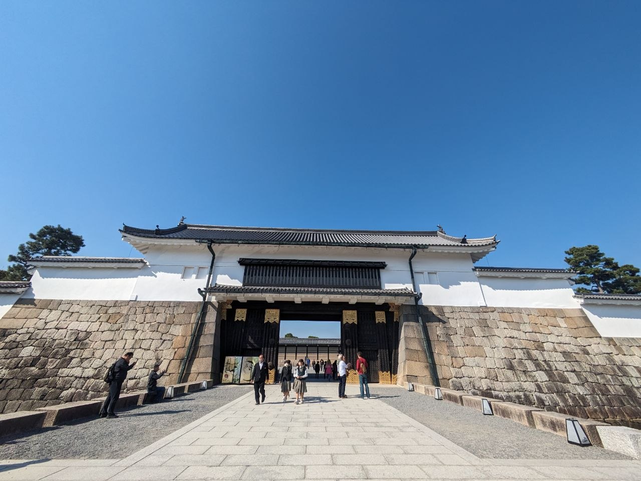 Main entrance gate of Nijo Castle with stone walls and visitors passing through