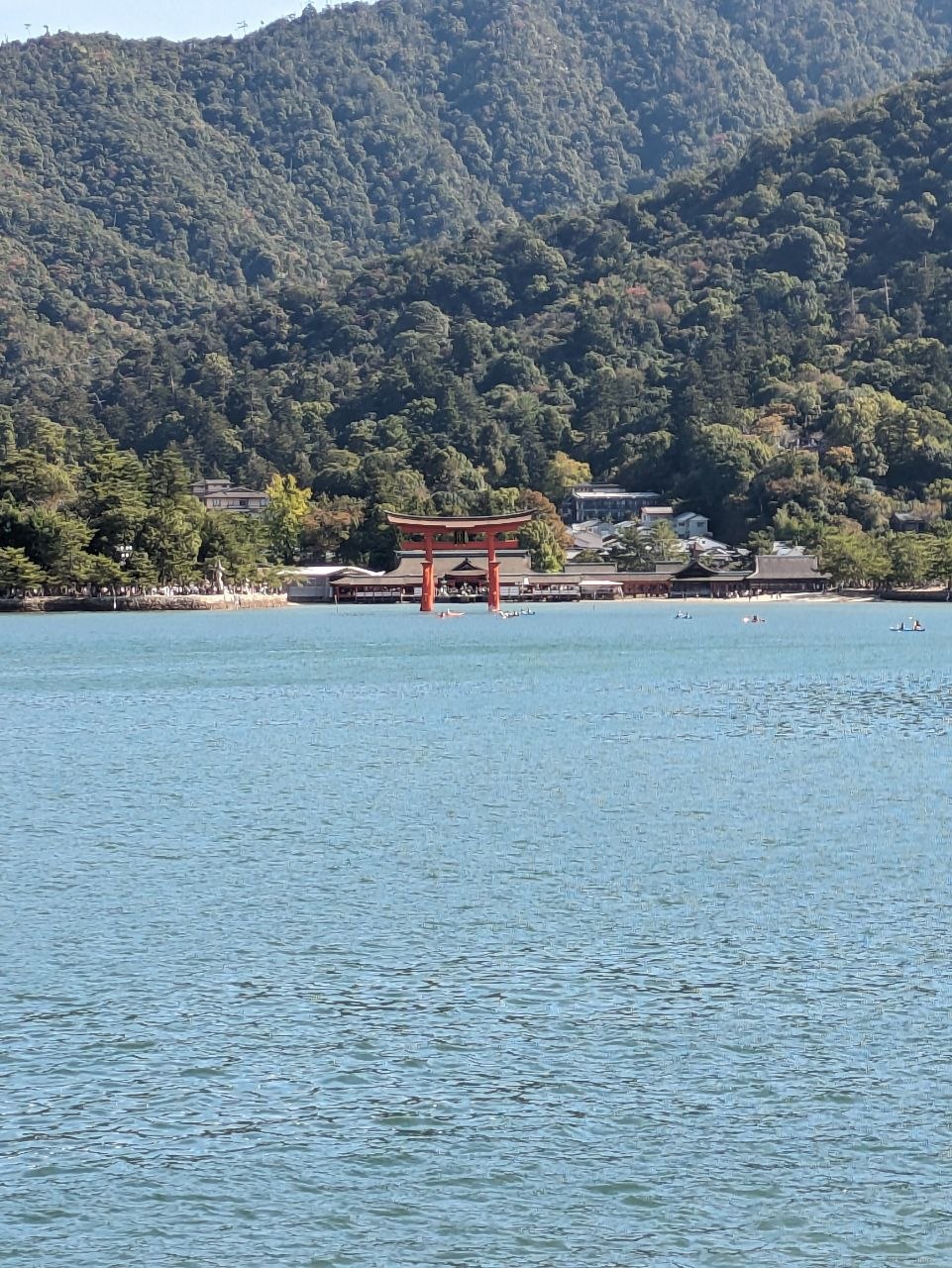 Distant view of Itsukushima Shrine and torii gate from the sea