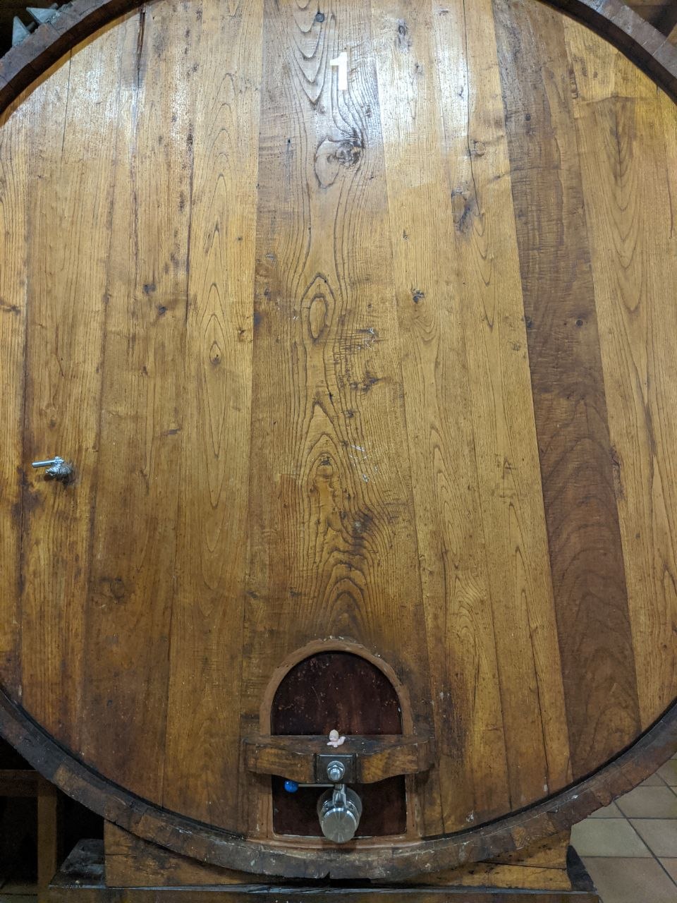 Large oak cider barrel numbered 1 with a metal tap at a Basque sagardotegia cider house near San Sebastián