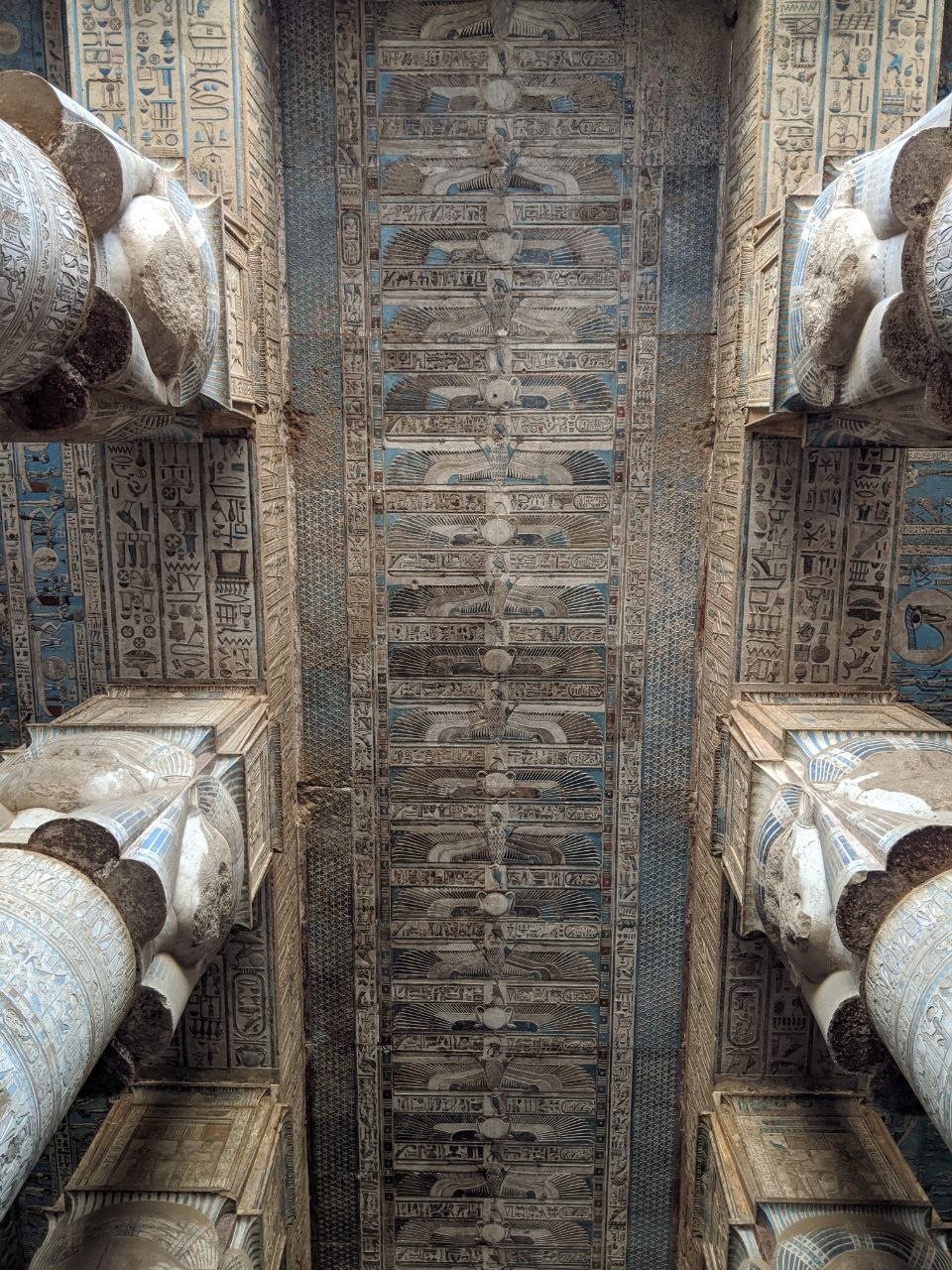 Facade of Dendera Temple of Hathor with six massive Hathor-headed columns and visitors at the entrance