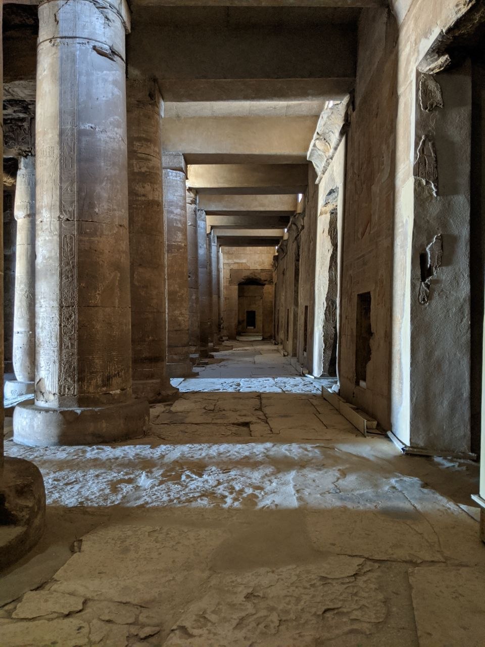 Interior colonnade of Abydos temple looking deep into the hypostyle hall with columns receding into shadow
