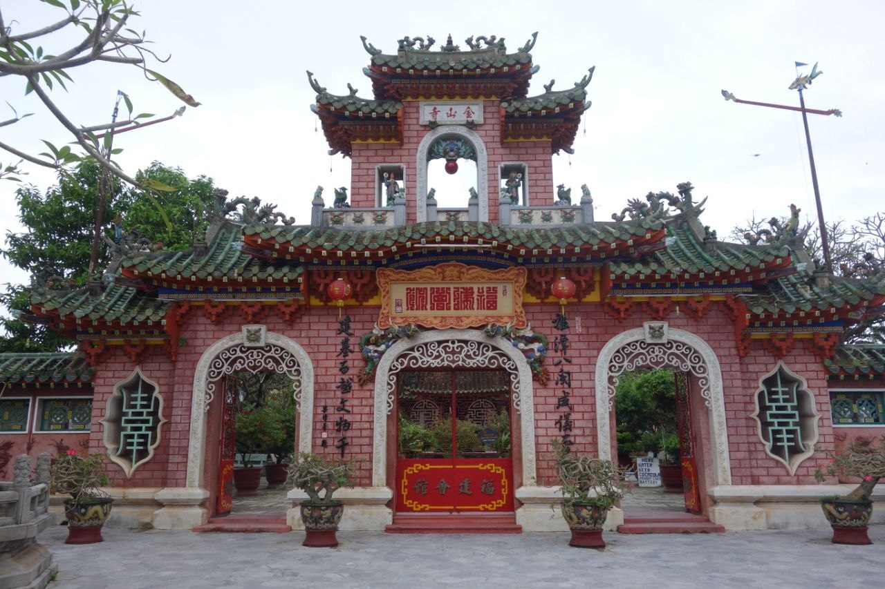 Facade of the Fujian Assembly Hall in Hoi An with ornate ceramic roof ridges and painted guardian figures