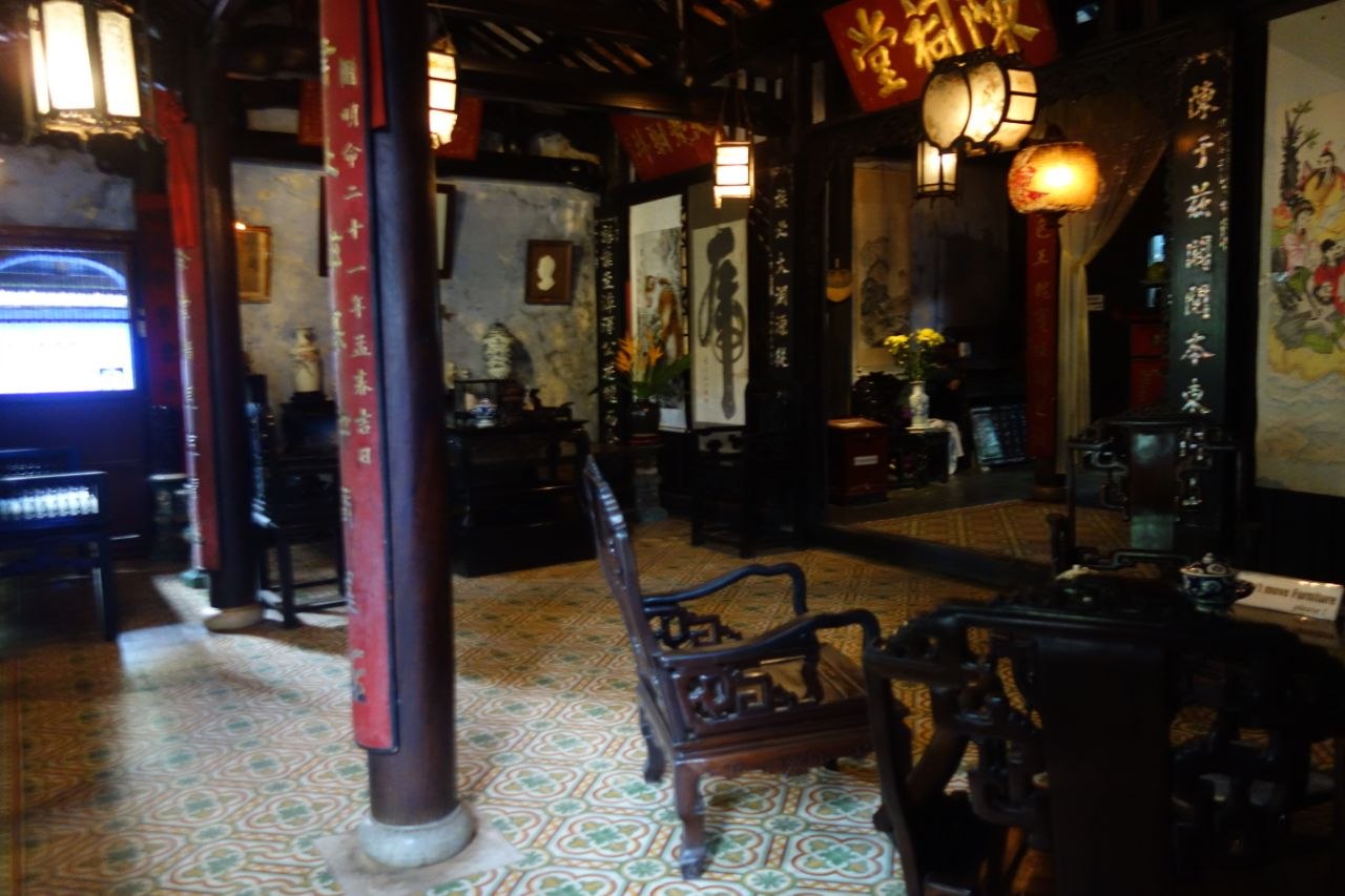 Interior of an ancient merchant townhouse in Hoi An with dark timber columns and traditional tiled roof